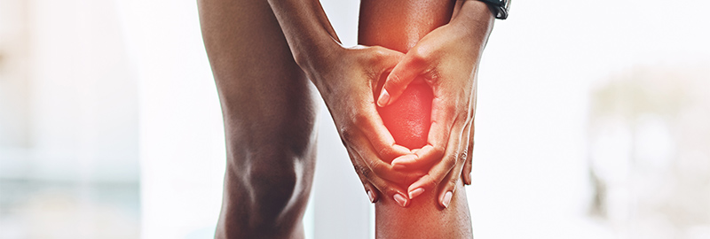 Close up shot of a woman holder her knee