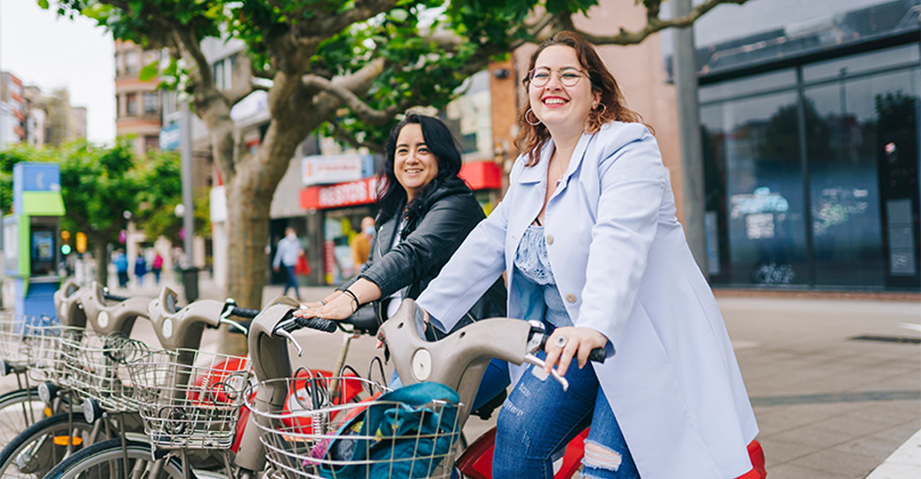 Two women on bikes on the street