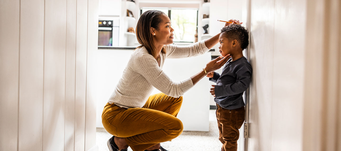 woman measuring child height