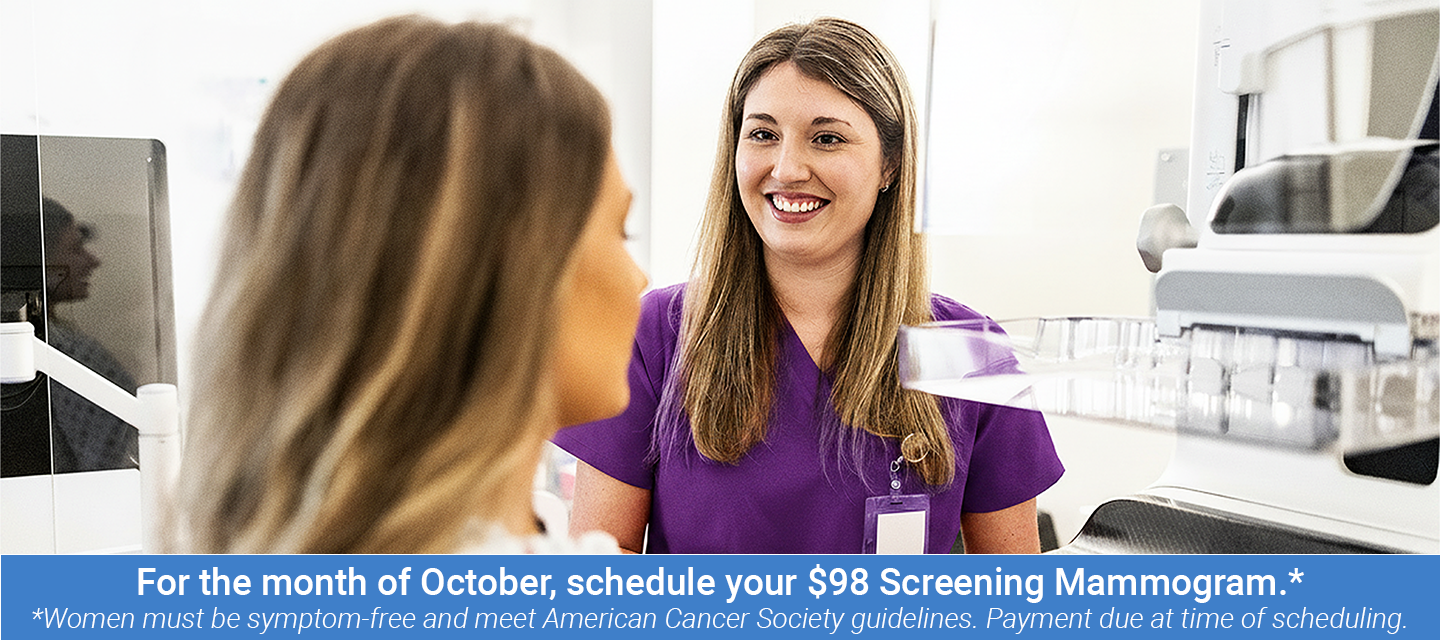 Nurse preparing female patient for mammogram in doctor's office