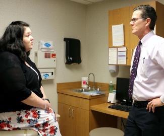 Douglas Dedelow, DO, chats with Alisa Keefe during a follow-up visit after her procedure.